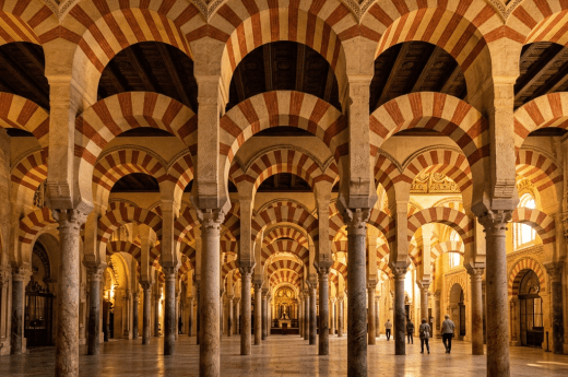 Interior of Mosque-Cathedral of Córdoba with red and white striped arches and marble columns